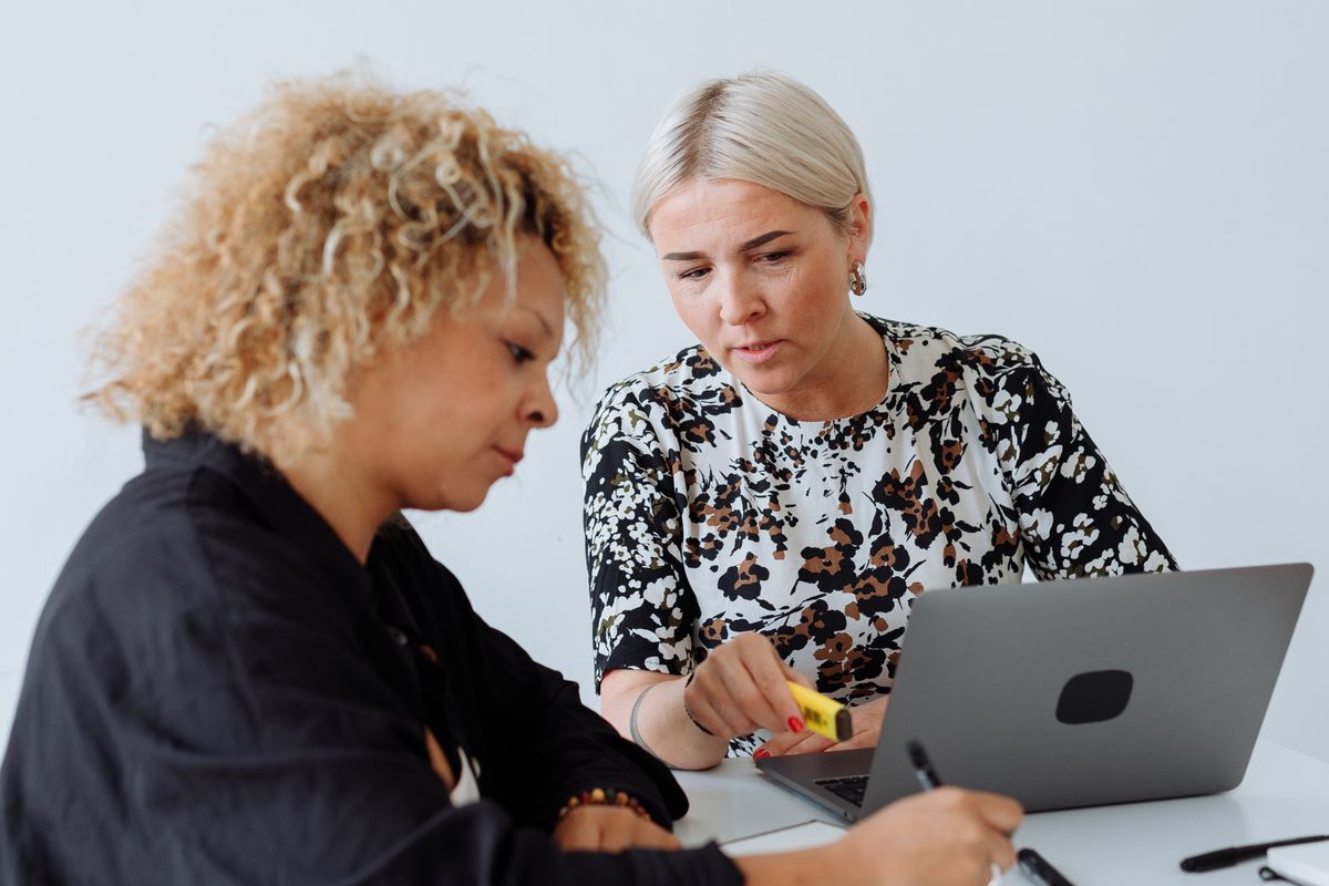 Two colleagues going through work on a laptop