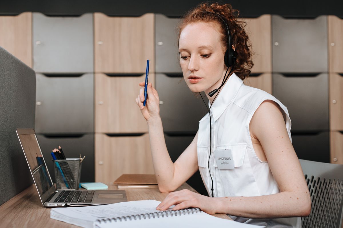 Woman with a headset working at a laptop