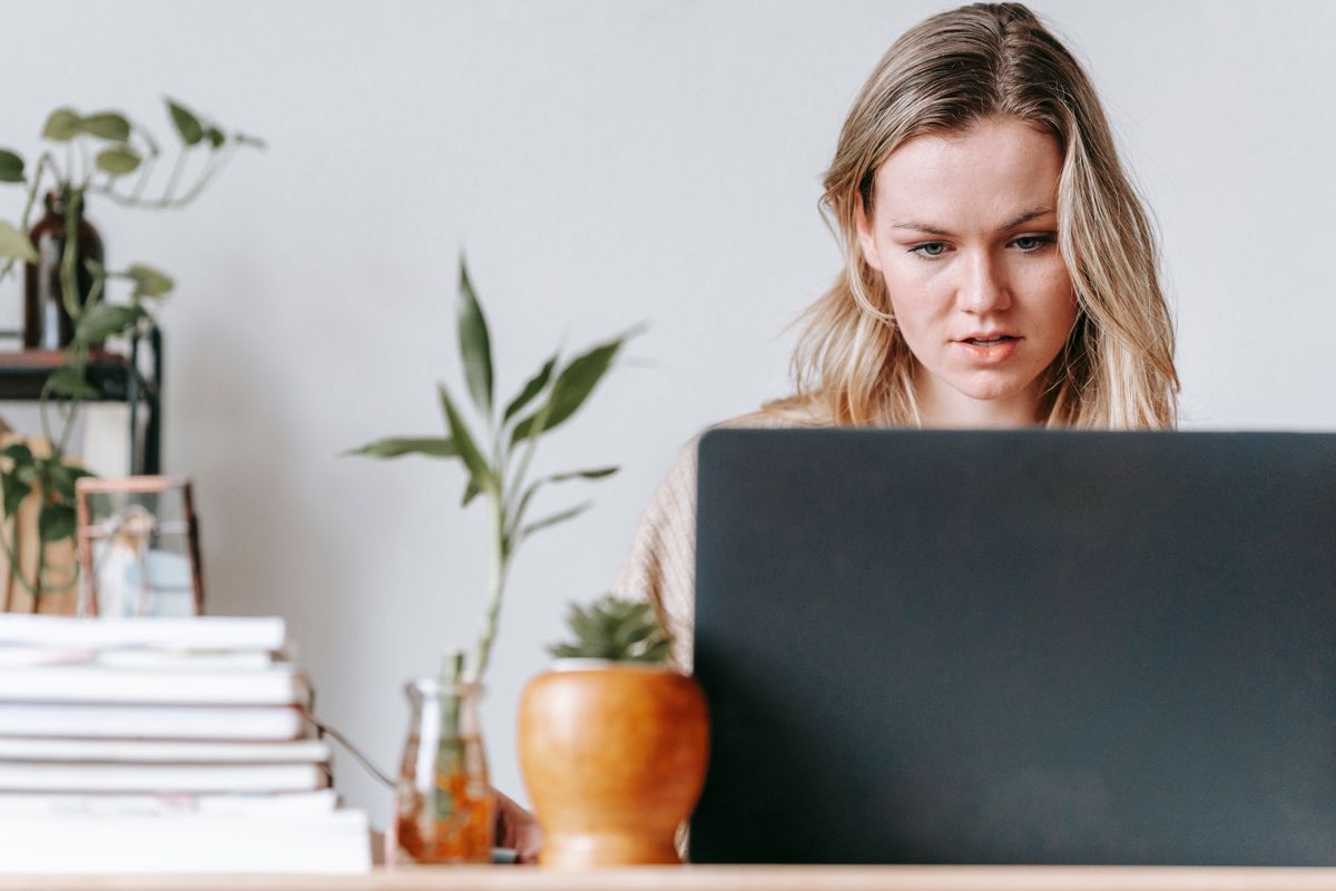 Woman focused on a laptop at a desk